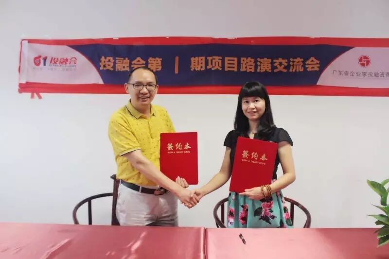签约仪式：双方代表手持签约本握手